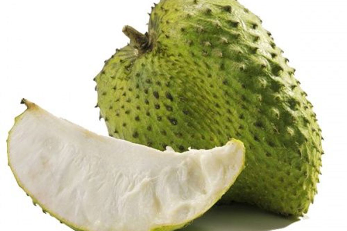 a green fruit with a slice cut in half