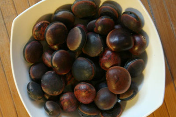 a bowl of chestnuts on a wood surface